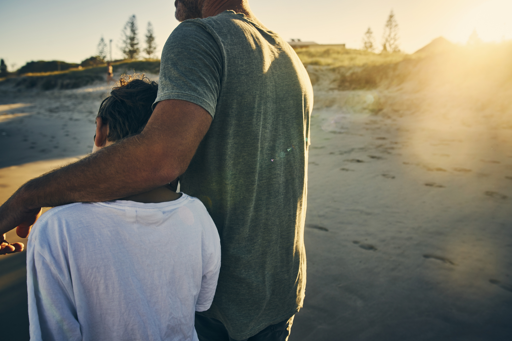 father walking with his arm around his son