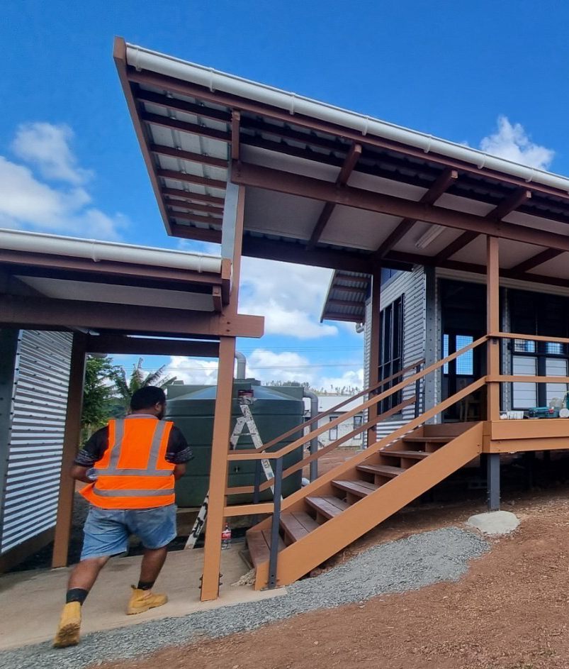 worker in reflective vest walking into building