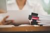 close up of documents with person out of focus at a desk behind them